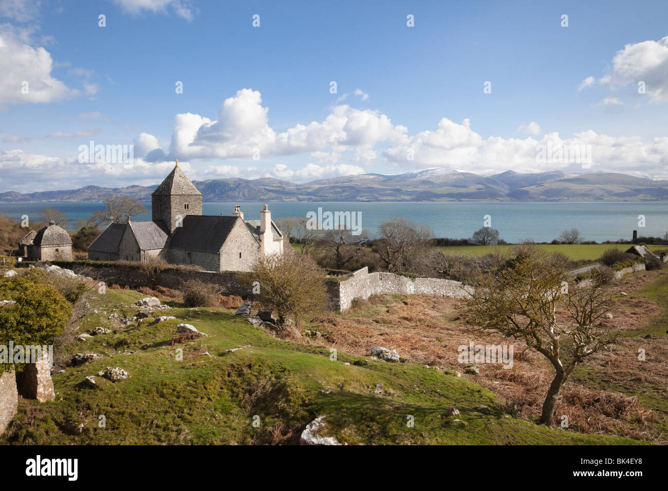 Penmon, Anglesey, au nord du Pays de Galles, Royaume-Uni. Penmon Prieuré (St. Monastère Seiriol's) et vue de côte Nord du Pays de Galles à travers le détroit de Menai Banque D'Images