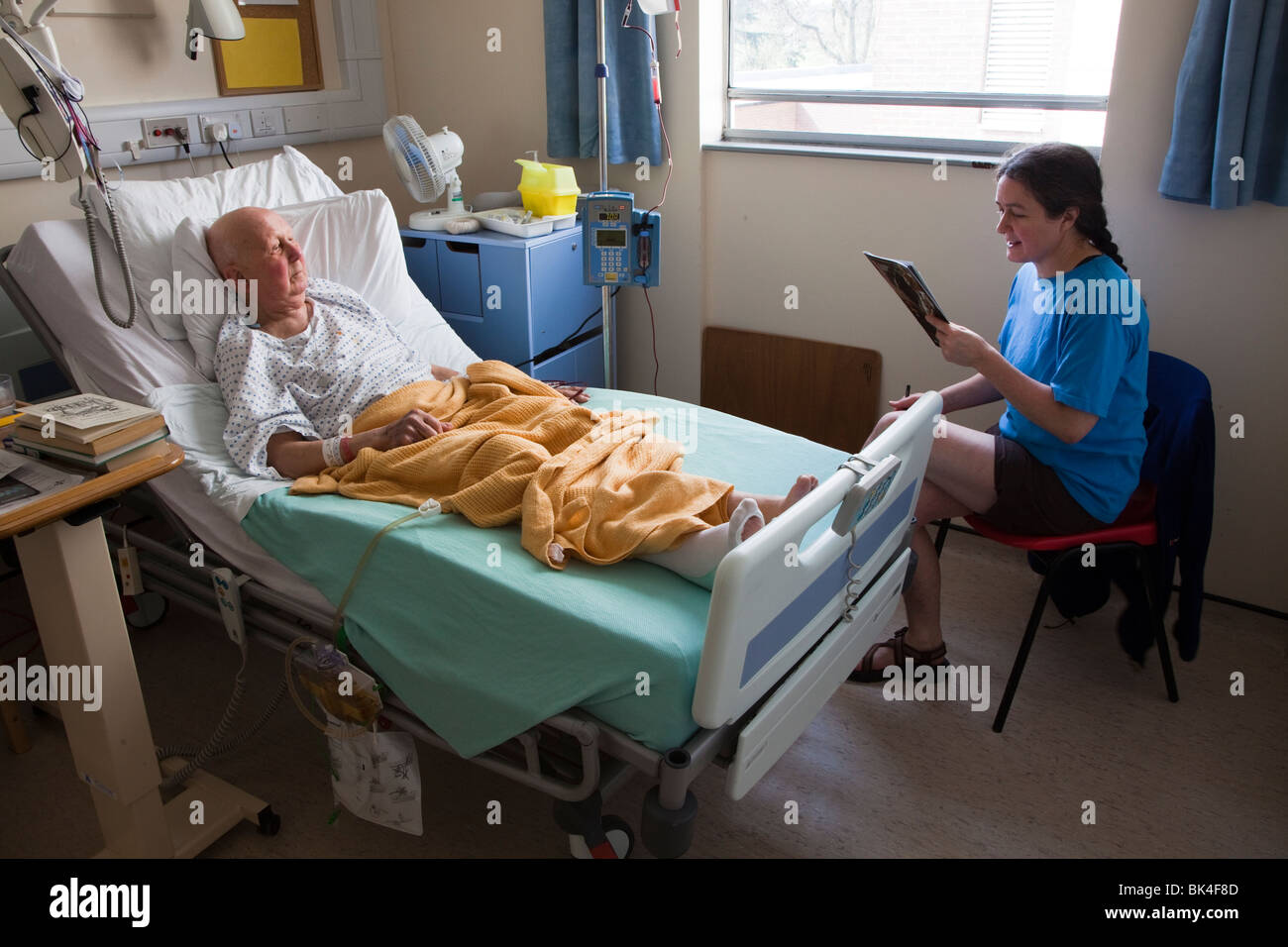 Patient in hospital bed avec le visiteur au Pays de Galles UK Banque D'Images