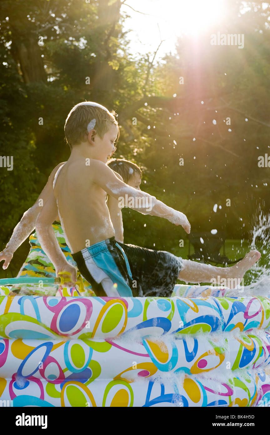 Les garçons jouant dans la piscine pleine de bulles Banque D'Images