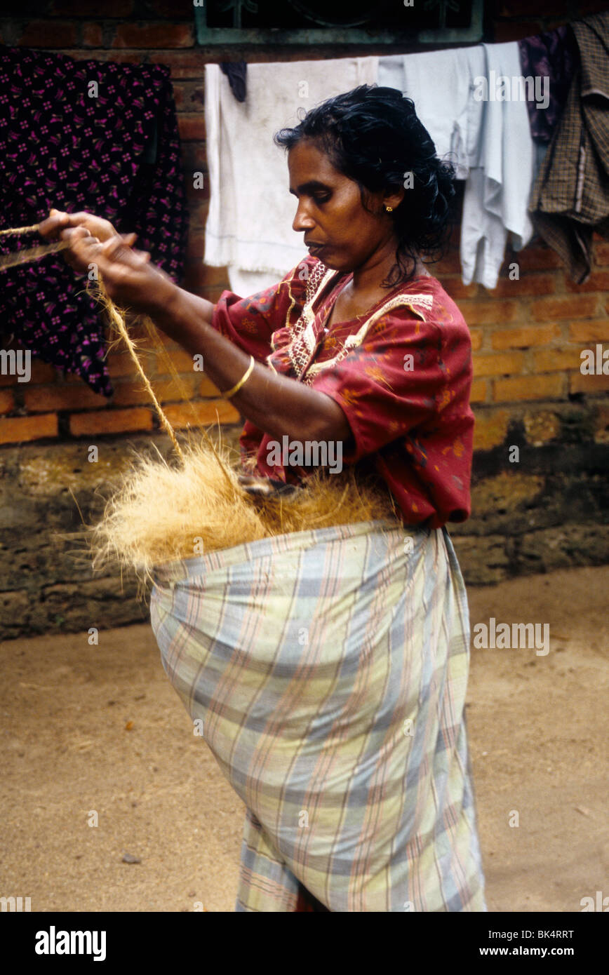 Femme avec la fabrication de cordes en fibre de coco Coco' dans 'façon traditionnelle dans un village d'eau dormante Banque D'Images