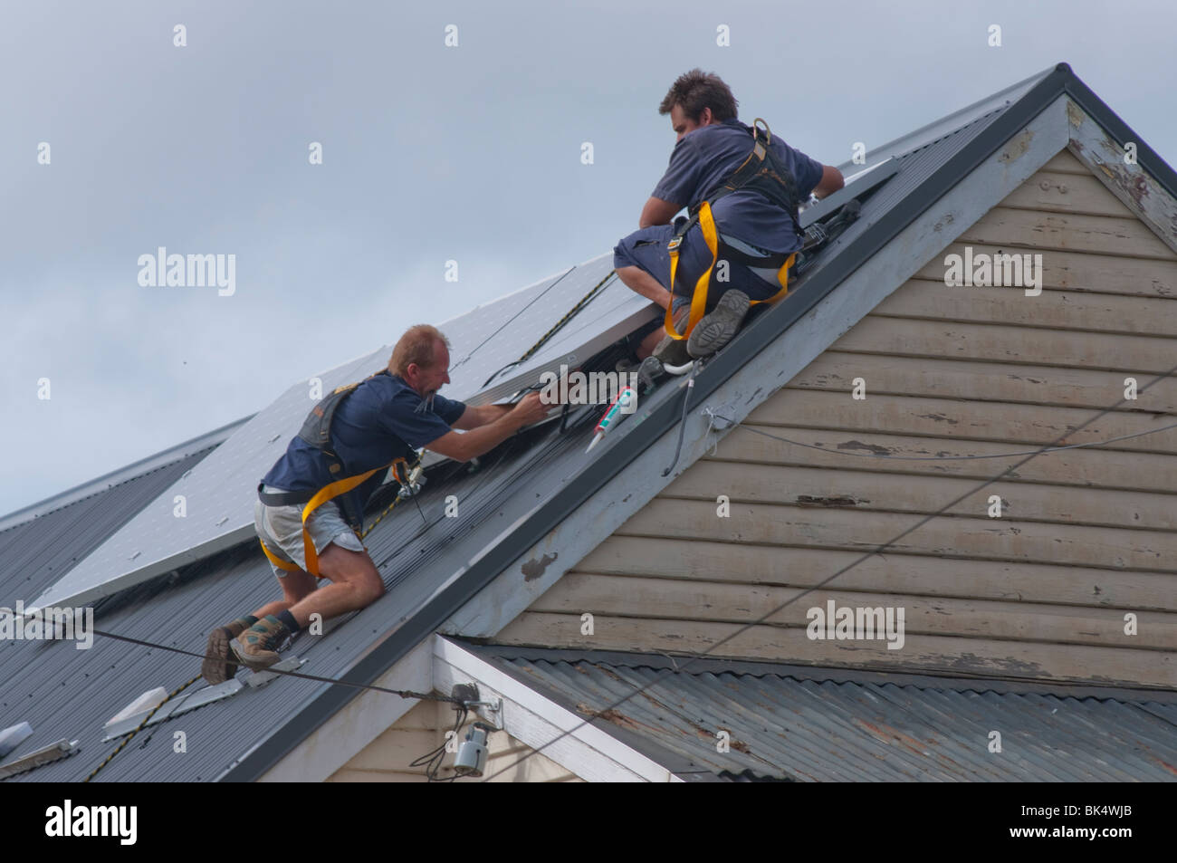 Ouvriers l'installation de panneaux solaires sur le toit d'Hobart Tasmanie Australie Banque D'Images