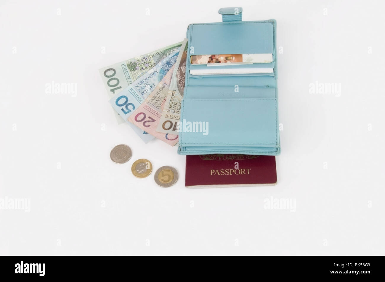 Mesdames wallet bleu clair avec de l'argent, monnaie polonaise, billets, pièces et passeport britannique, fond blanc, cut-out, voyages Banque D'Images