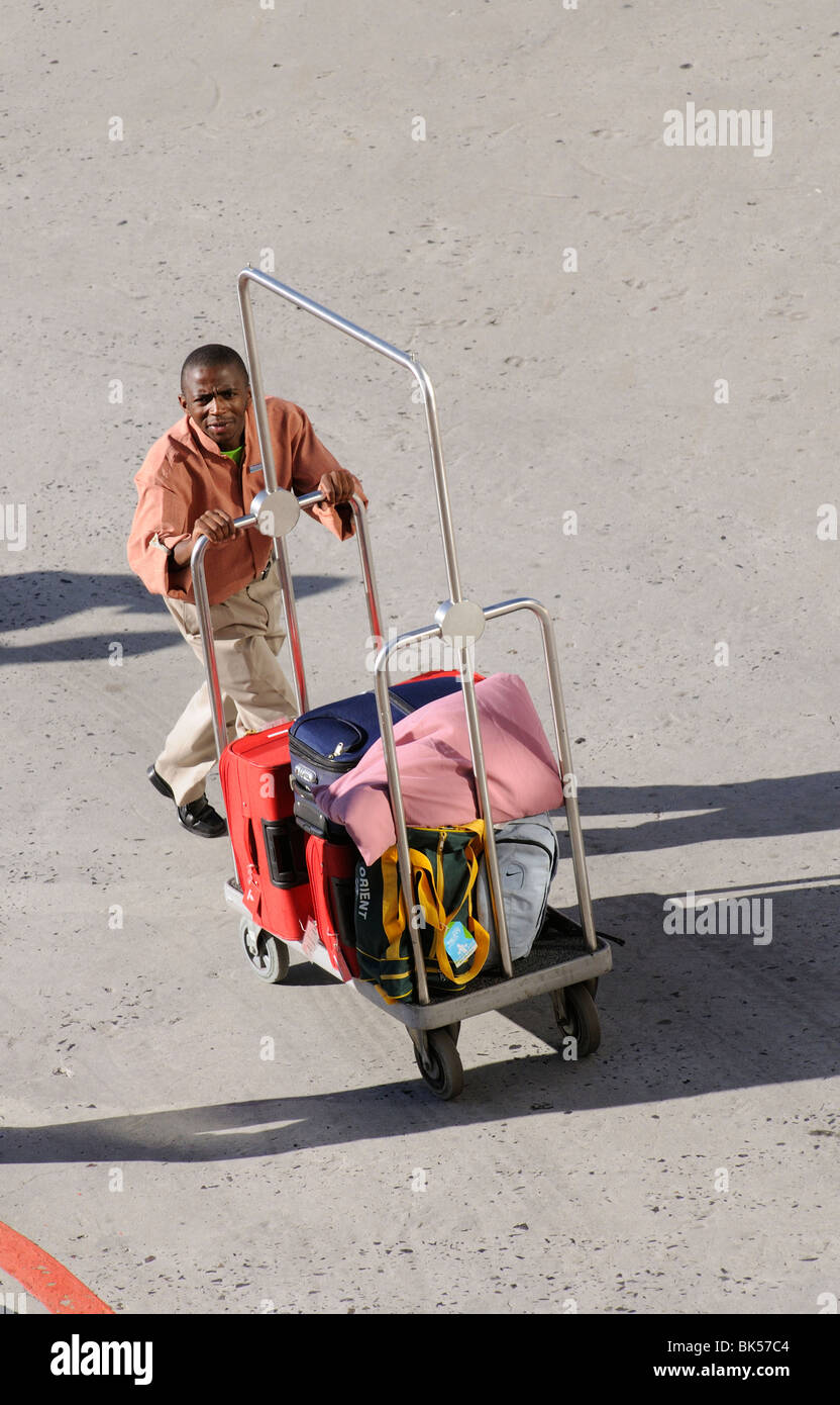 Chasseur de l'hôtel vous poussant une assurance sur son chariot Banque D'Images