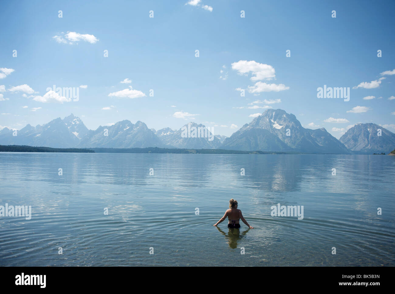 Femme patauge dans le lac avec Tetons à distance, Parc National de Grand Teton, Wyoming, États-Unis d'Amérique, Amérique du Nord Banque D'Images