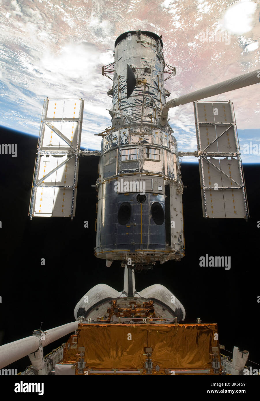 La navette spatiale Atlantis' lève le bras du télescope spatial Hubble de la baie de chargement Banque D'Images