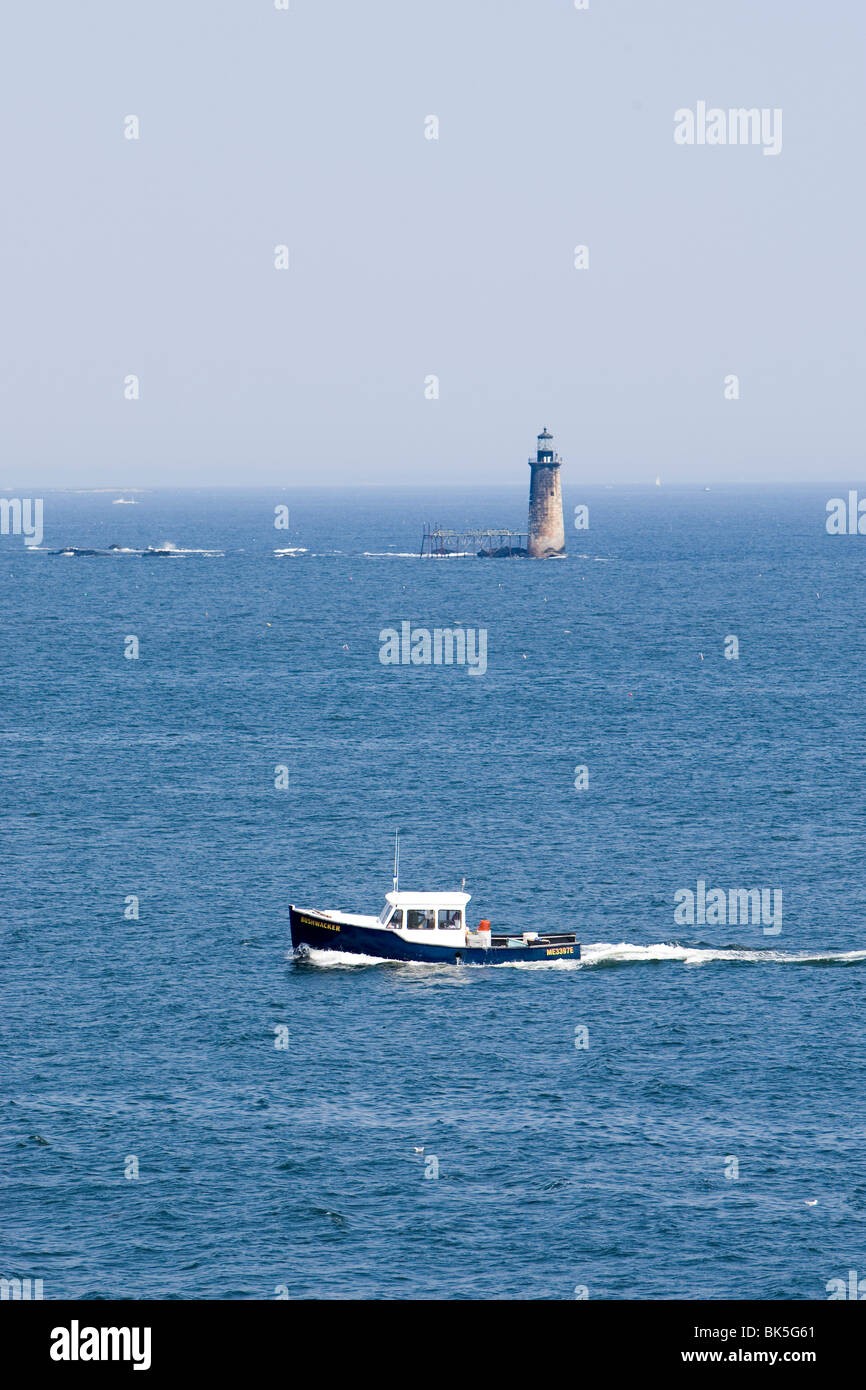 Un bateau de pêche et un phare au large de la côte de Cape Elizabeth Maine Banque D'Images