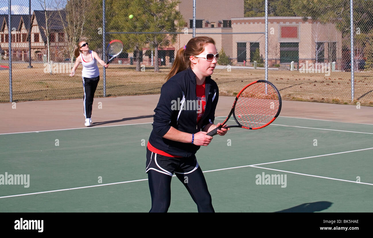 Les jeunes filles du secondaire sur une équipe de tennis de jouer un match  sur un après-midi de printemps ensoleillé Photo Stock - Alamy