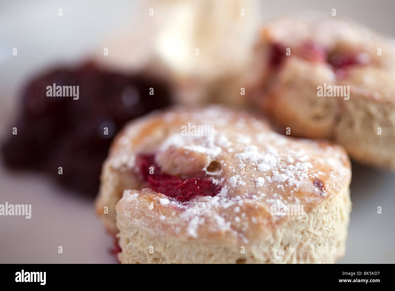 Des scones aux fraises et de la confiture de fraise close up montrant la texture de la nourriture sur une table Banque D'Images