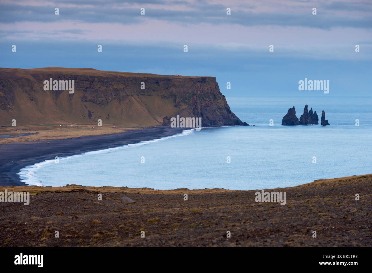 Plage de sable noir, rock formation et la mer de Reynisdrangar cheminées de la distance, de Dyrholaey près de Vik, l'Islande, les régions polaires Banque D'Images