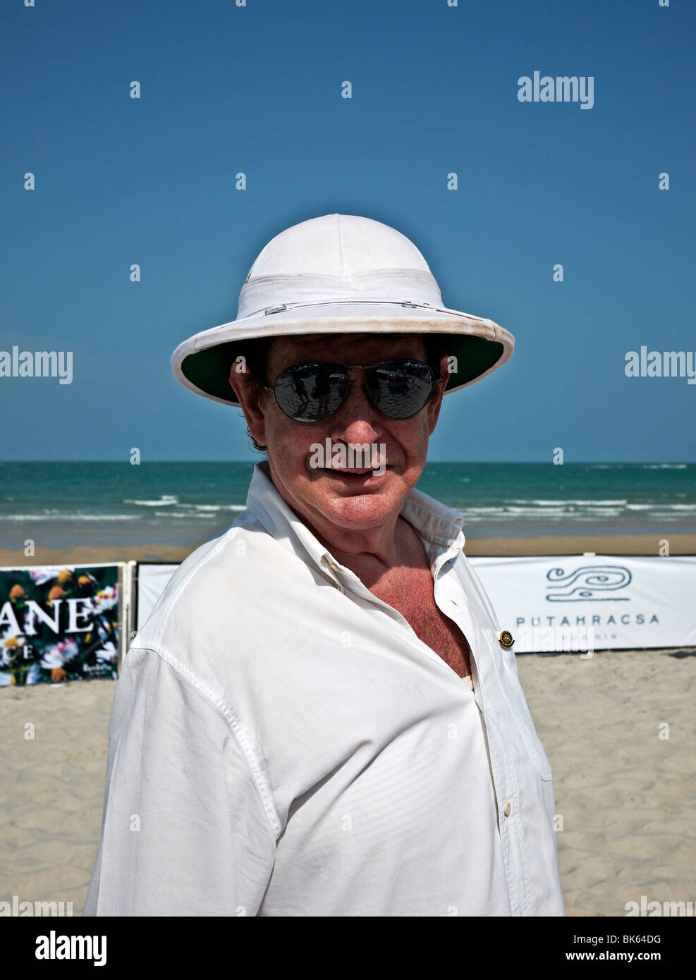 Homme mature portant un casque colonial à une plage tropicale. Banque D'Images