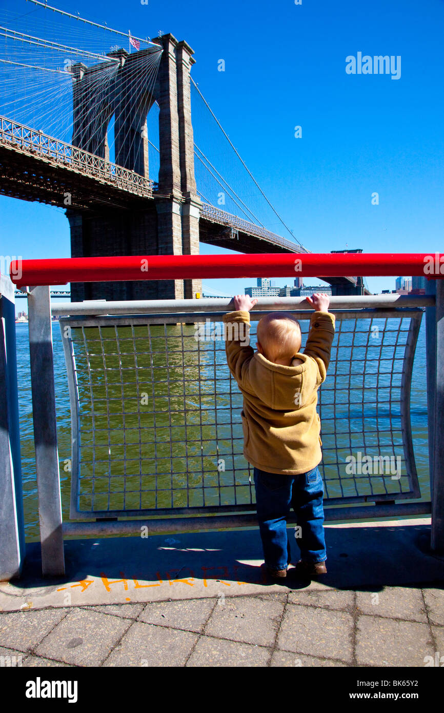 Jeune garçon en face du pont de Brooklyn à Manhattan, New York Banque D'Images