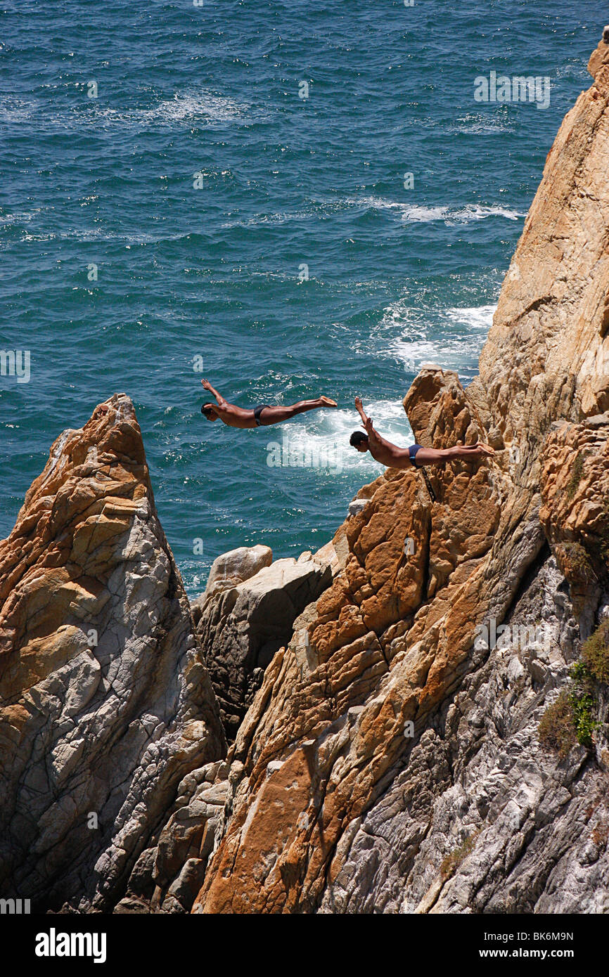 Deux plongeurs faire un «plongée wan' désactivé les célèbres falaises de la Quebrada dans l'océan turbulent ,Baie de Acapulco, Mexique Banque D'Images