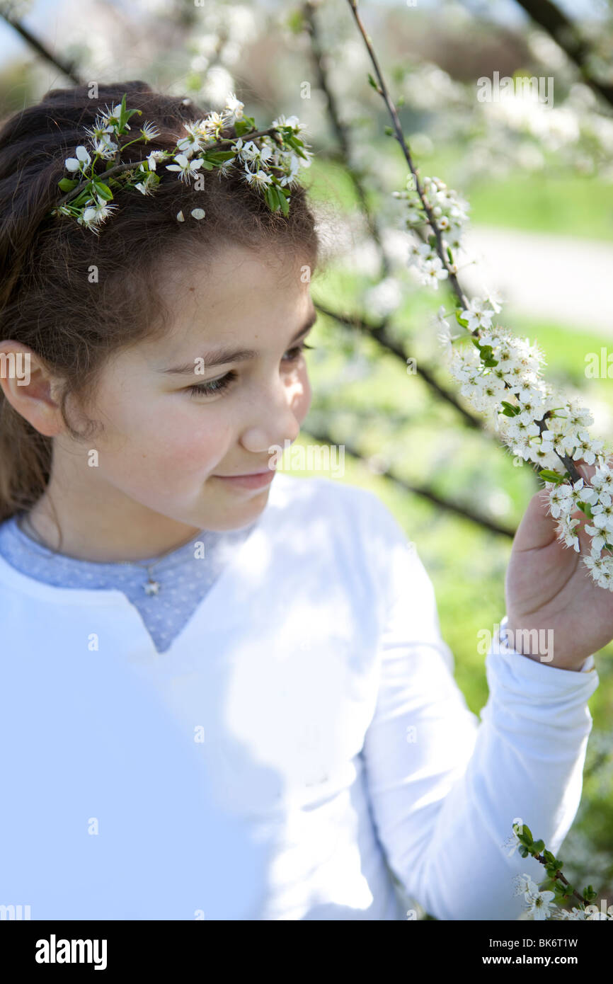 Jolie petite fille de toucher un cerisier en fleurs Banque D'Images
