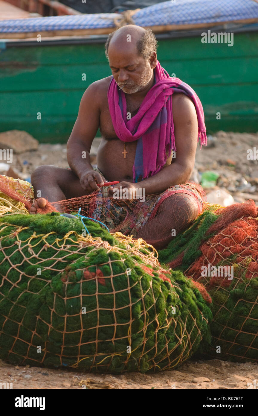 Il s'agit d'une image d'un pêcheur indien du sud raccommodage des filets de pêche. Banque D'Images