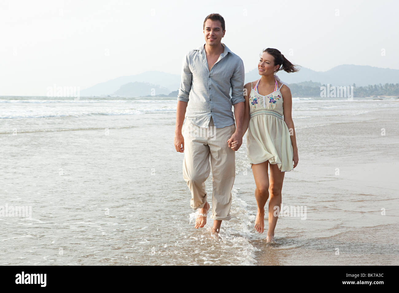 Couple en train de marcher dans la mer Banque D'Images