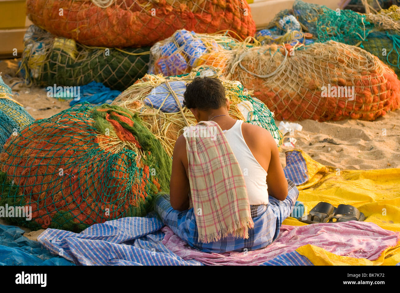 Il s'agit d'une image d'un pêcheur indien du sud raccommodage des filets de pêche. Banque D'Images