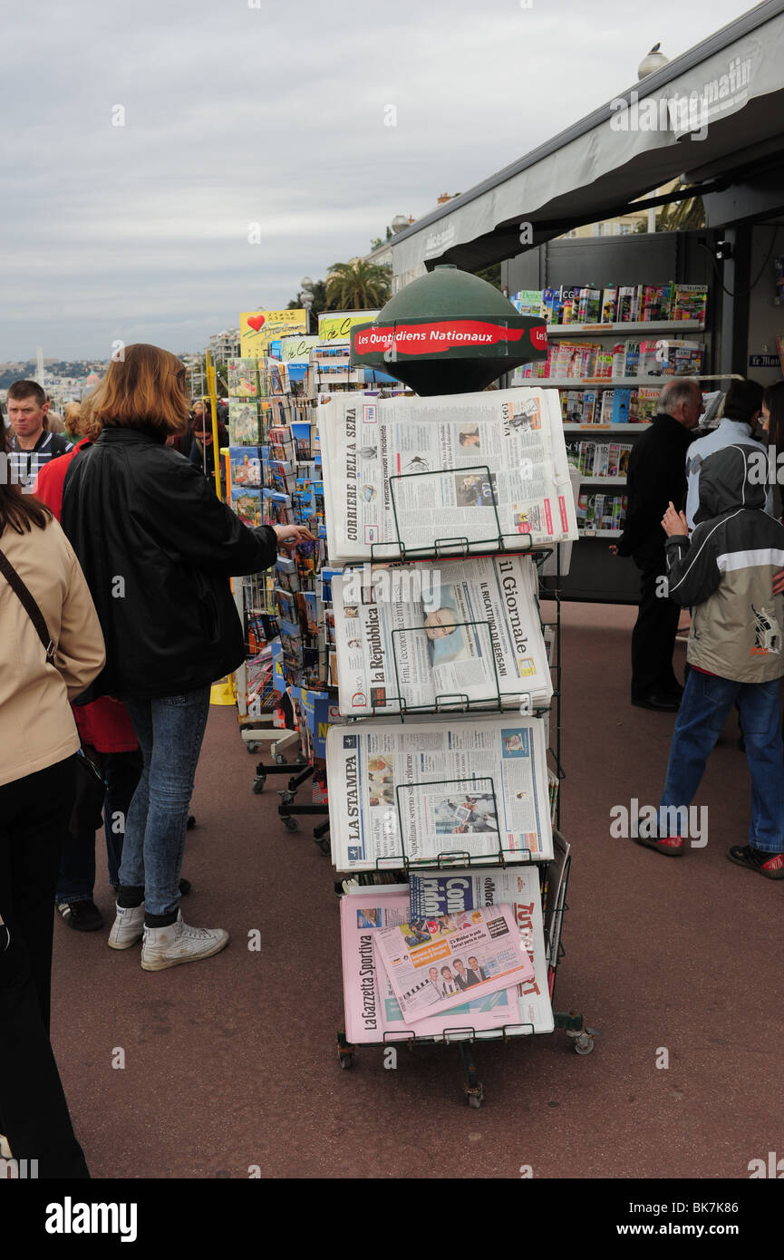 Europe France Nice Cote d'Azur Provence Nice people à la recherche des journaux gratuits à un kiosque sur la promenade de l'anglais Banque D'Images