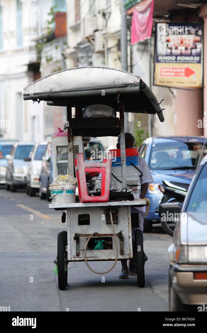 Un Hawker poussant son échoppe le long d'une rue à Penang, Malaisie Banque D'Images