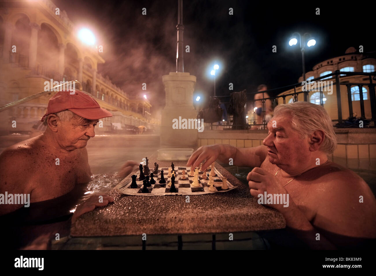 Les hommes jouant aux échecs dans les bains de Szechenyi sur une froide nuit d'hiver à Budapest, Hongrie Banque D'Images