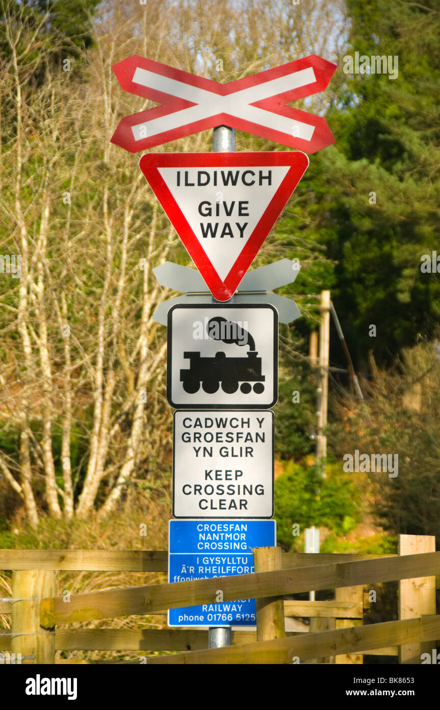 Gallois et Anglais bilingue des panneaux d'avertissement à un passage à niveau, chemin de fer, Nantmor Welsh Highland, Snowdonia, le Nord du Pays de Galles, Royaume-Uni Banque D'Images