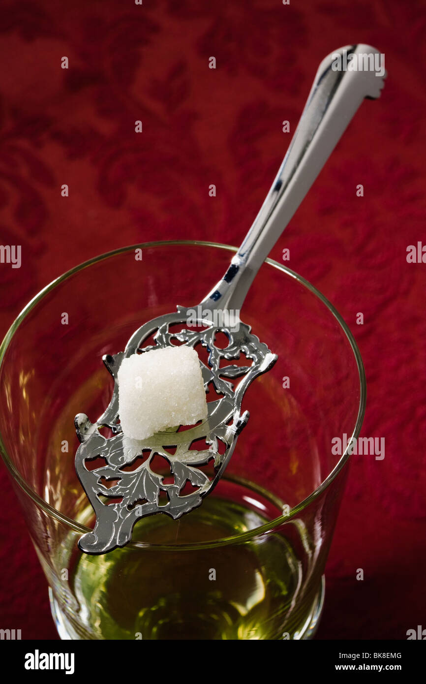 Jeu de l'absinthe jusqu'à verser de l'eau , cube de sucre sur la cuillère à  absinthe en équilibre sur verre Cordon Photo Stock - Alamy