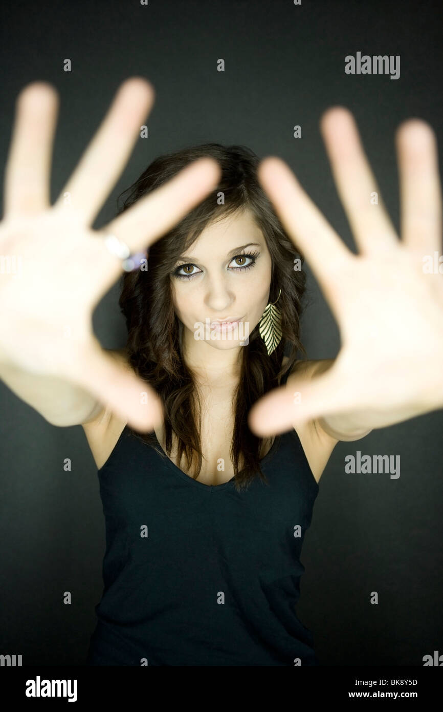 Adolescente à la recherche à travers ses mains Banque D'Images