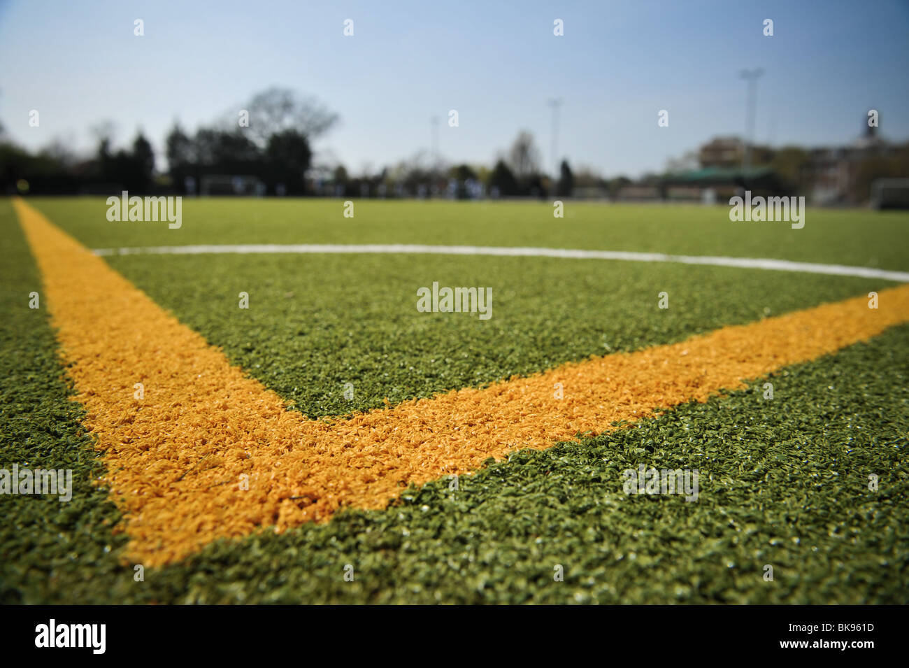 Un gros plan d'une section d'angle d'un terrain de soccer ou de football à un club amateur. Aussi illustré, un ciel bleu clair. Banque D'Images