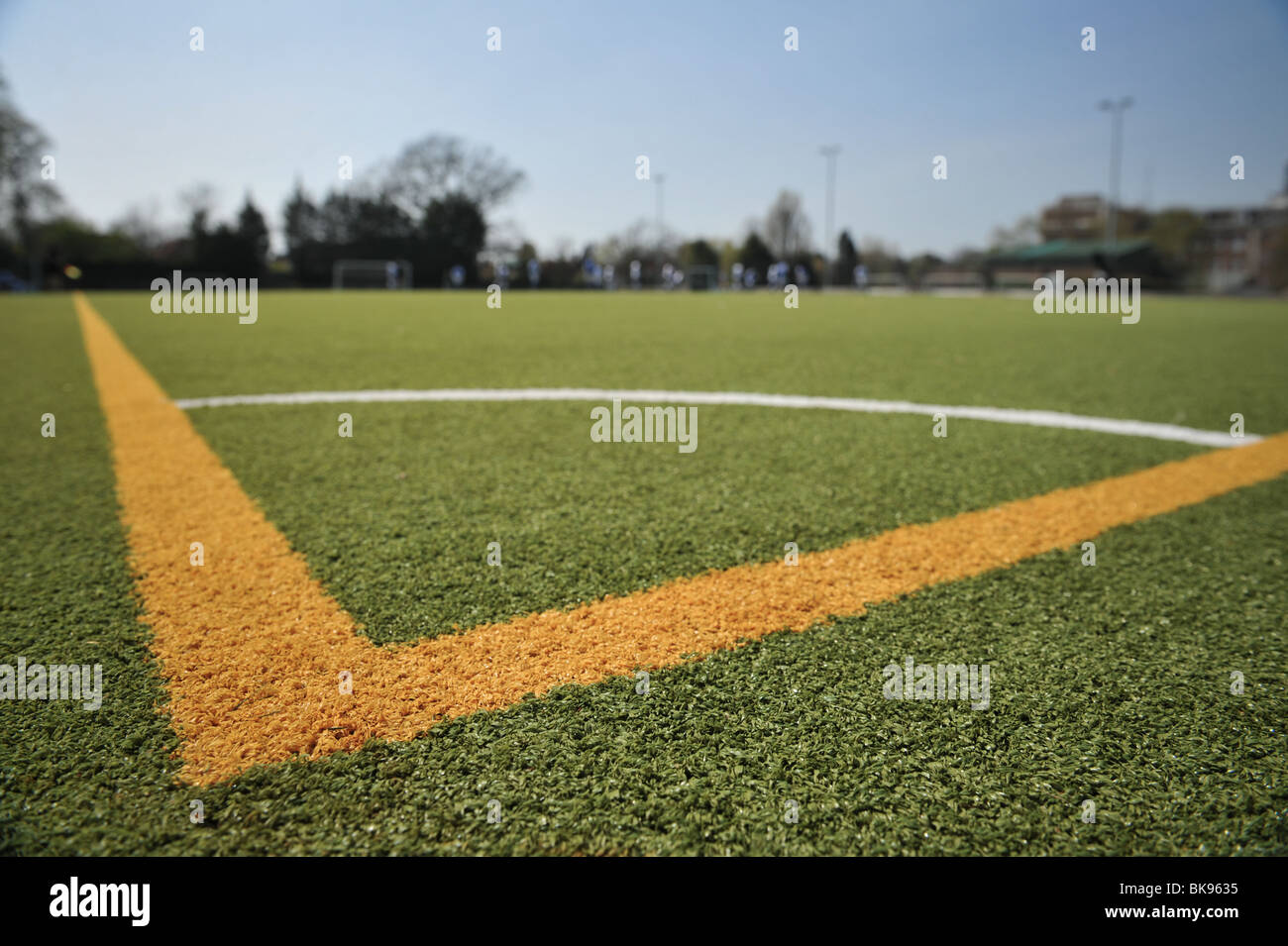 Un gros plan d'une section d'angle d'un terrain de soccer ou de football à un club amateur. Aussi illustré, un ciel bleu clair. Banque D'Images