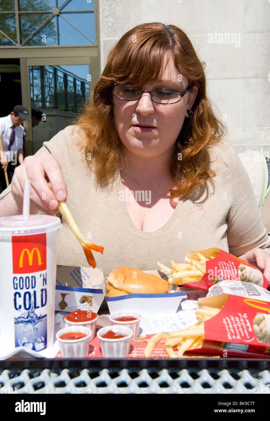 L'excès de woman eating fast-food McDonald's Banque D'Images