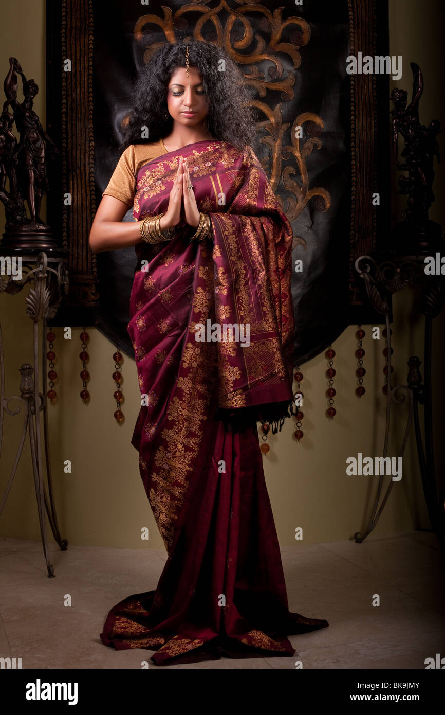 Belle femme indienne dans l'article namaste posent portant sari. Banque D'Images