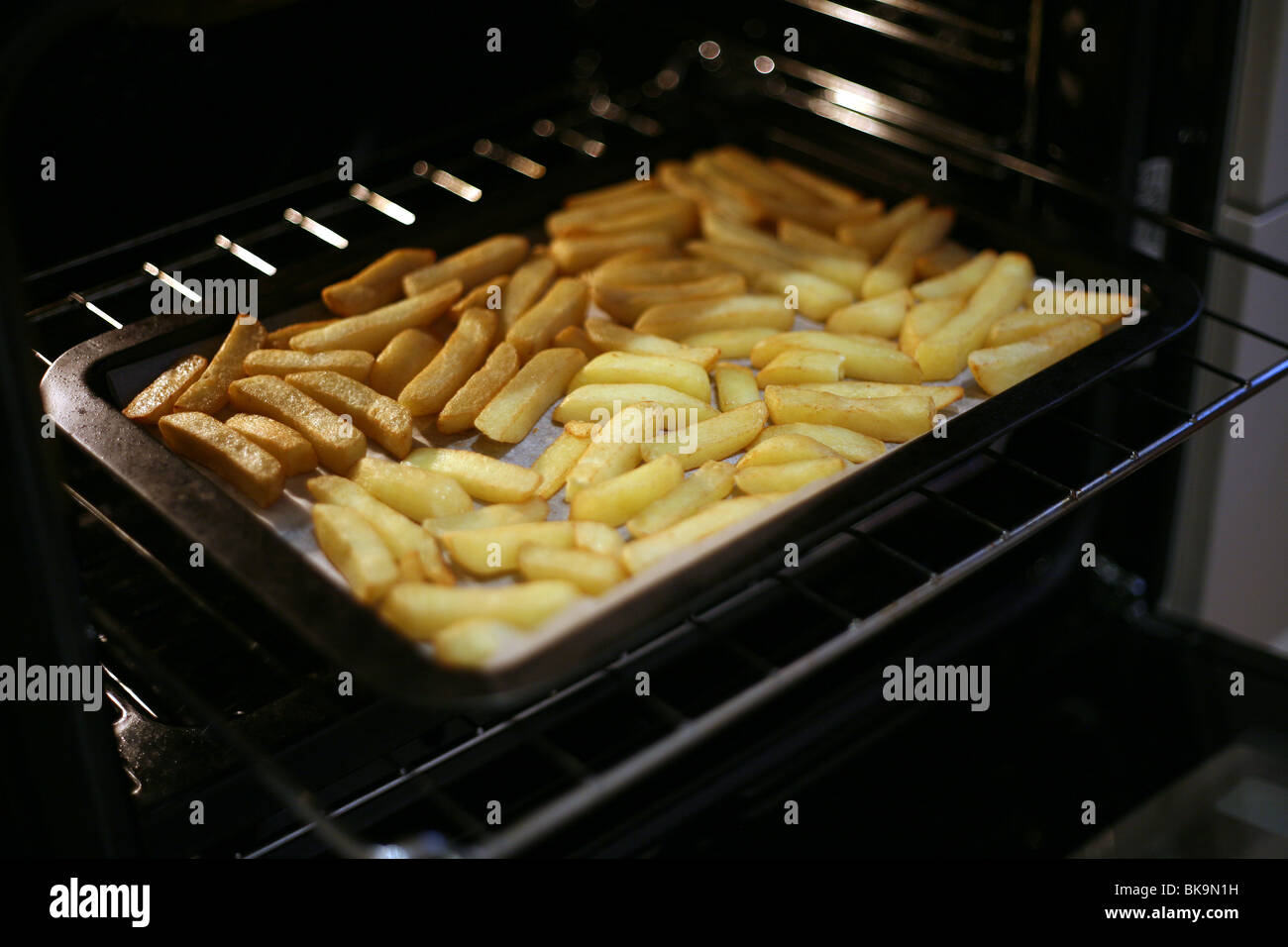 Frites au four qui sortent du four Banque D'Images