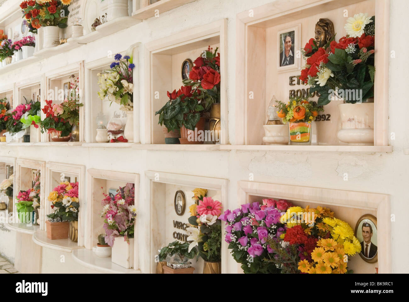 Fleurs en plastique sur une tombe familiale. Photographie de la personne décédée. Capalbio Toscane Italie. HOMER SYKES des années 2010 2010 Banque D'Images