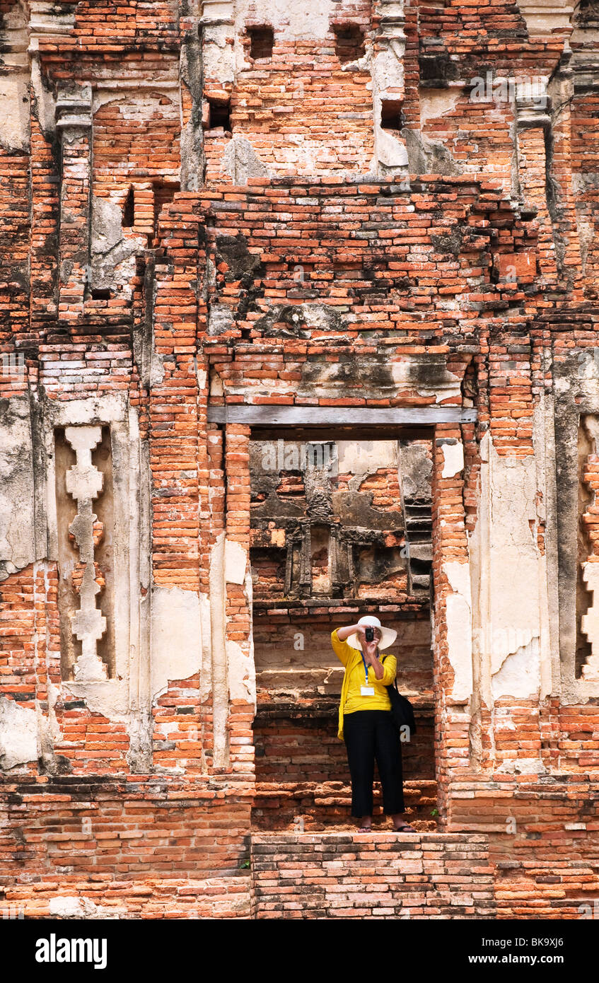 Wat Chaiwatthanaram temple bouddhiste d'Ayutthaya, Thaïlande, avec femme visiteur photographier les ruines. Banque D'Images