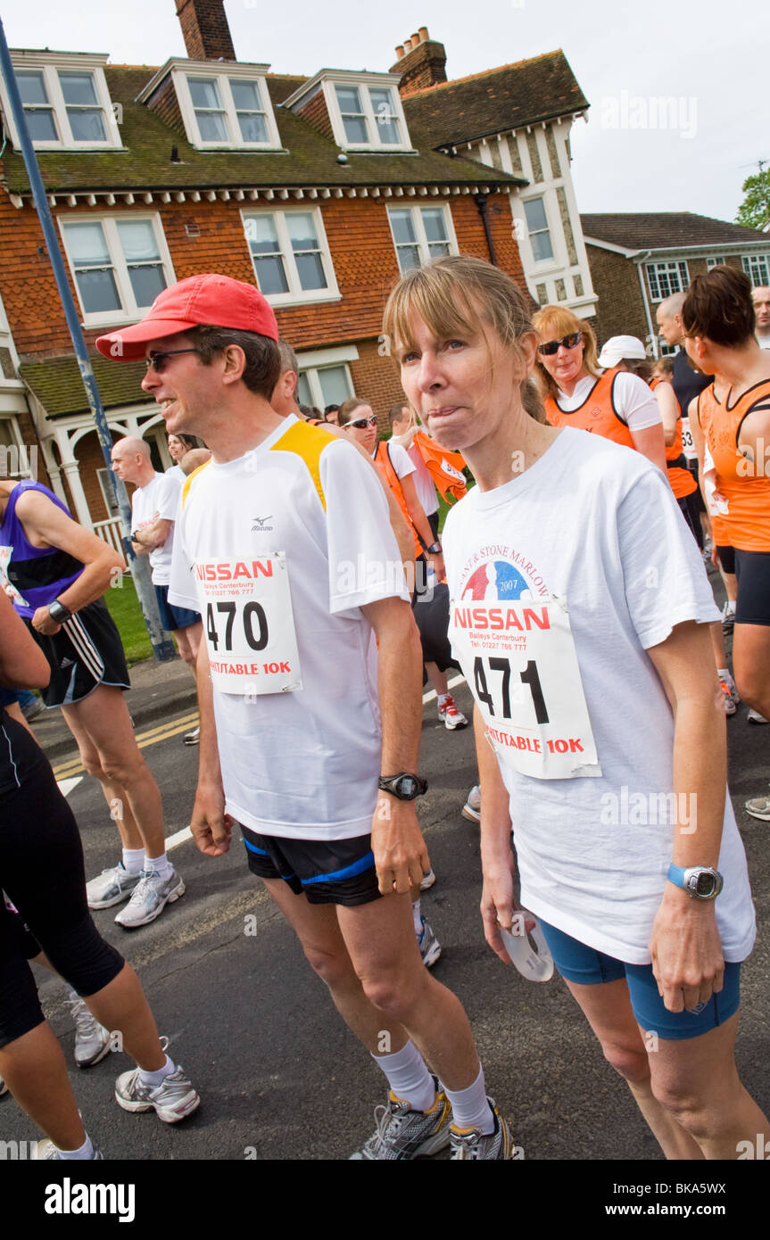 Des groupes de coureurs la collecte dans la rue avant le début d'une course de bienfaisance de 10 km Banque D'Images