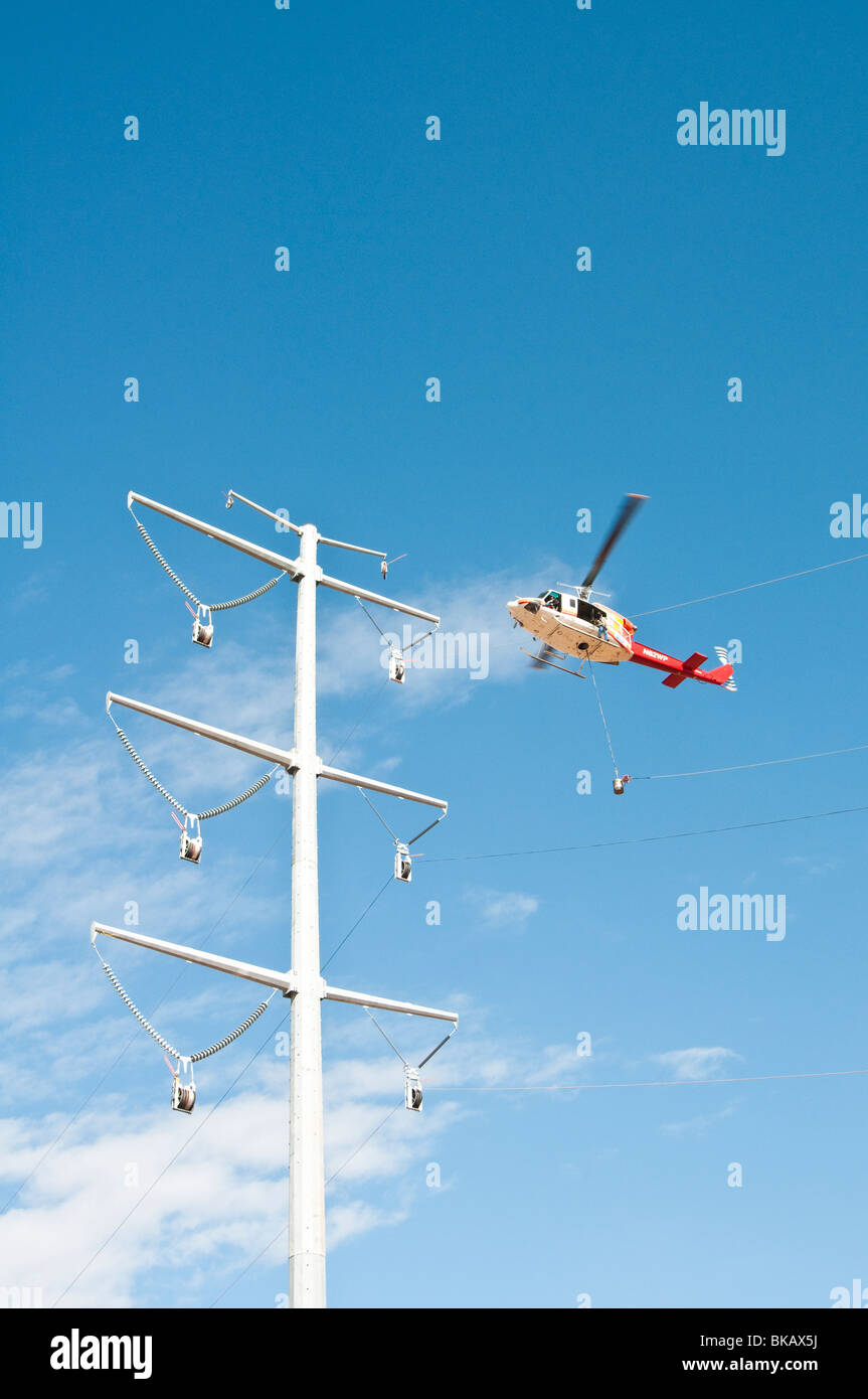 Un hélicoptère est utilisé pour une chaîne câble pendant la construction d'une nouvelle ligne d'alimentation Banque D'Images