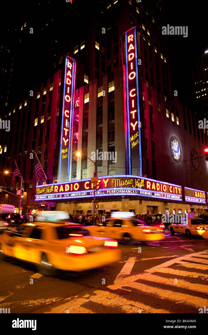 Les taxis en voiture par le Radio City Music Hall à Manhattan, New York City USA Banque D'Images
