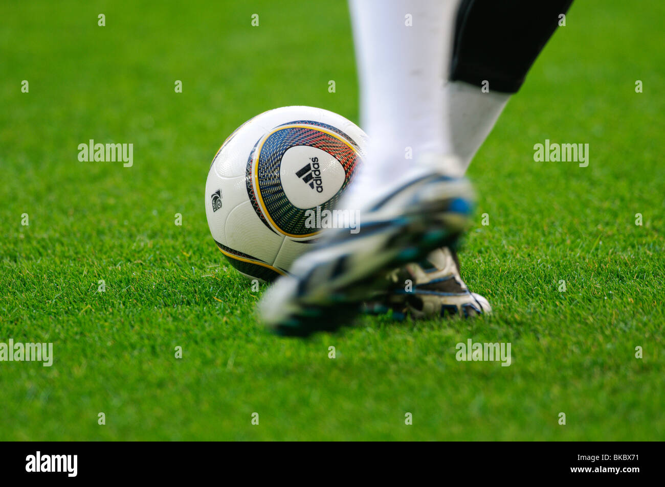 Joueur de football kicks Jabulani, matchball officielle de FIFA World Cup 2010 en Afrique du Sud sur le terrain Banque D'Images