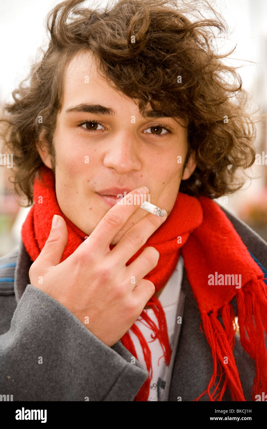 Bon à teenage boy à la caméra en fumer une cigarette Banque D'Images