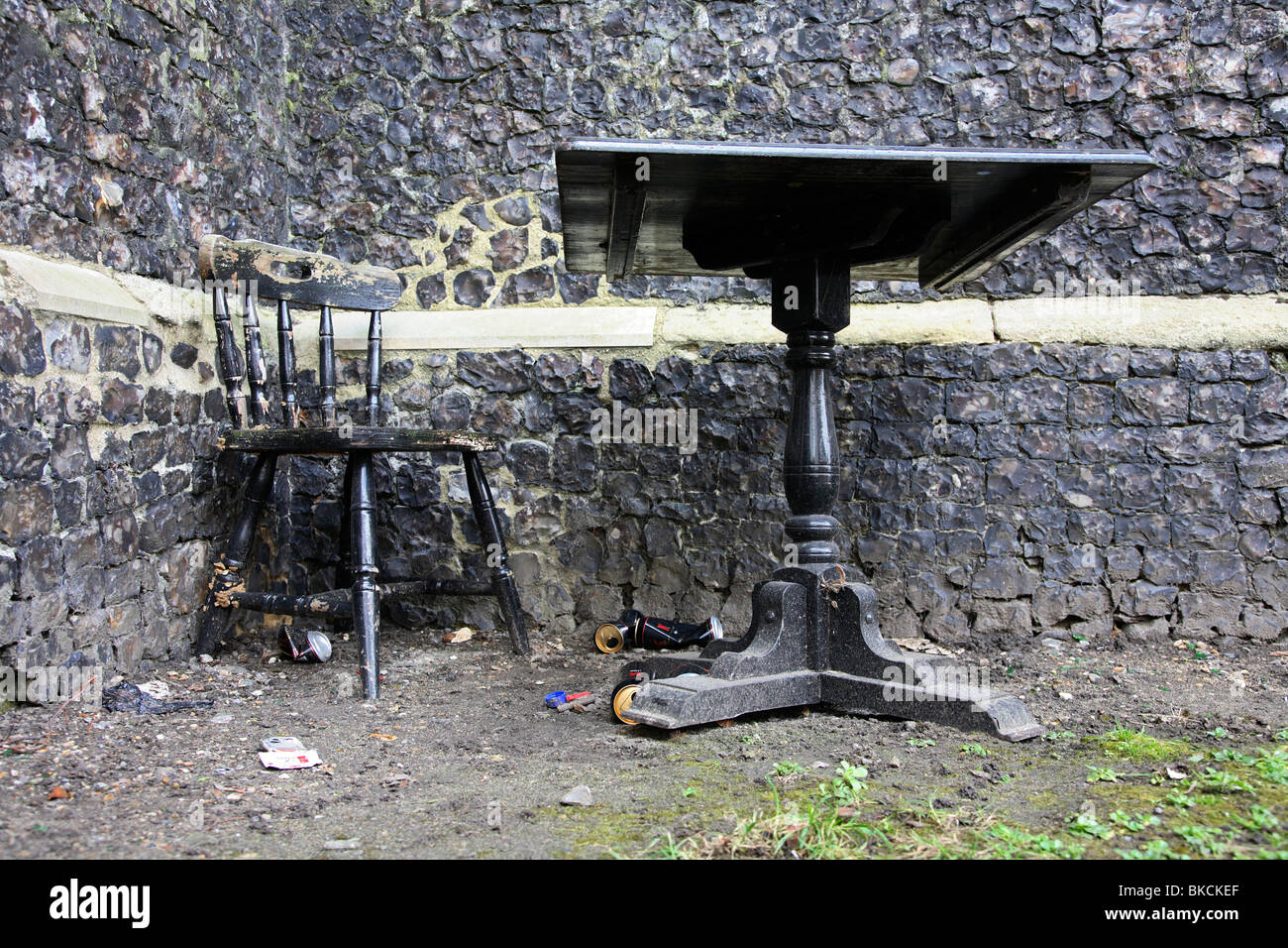 Table et chaise à côté d'un vieux mur de pierre de l'église. Banque D'Images