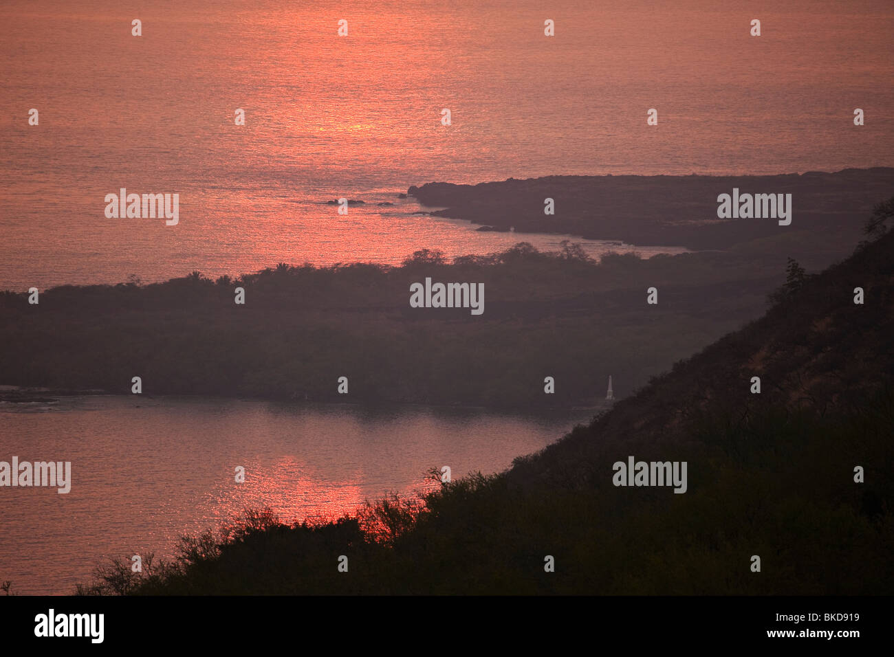 Vue du coucher de soleil de la baie de Kealakekua avec Captain Cook Monument. Banque D'Images