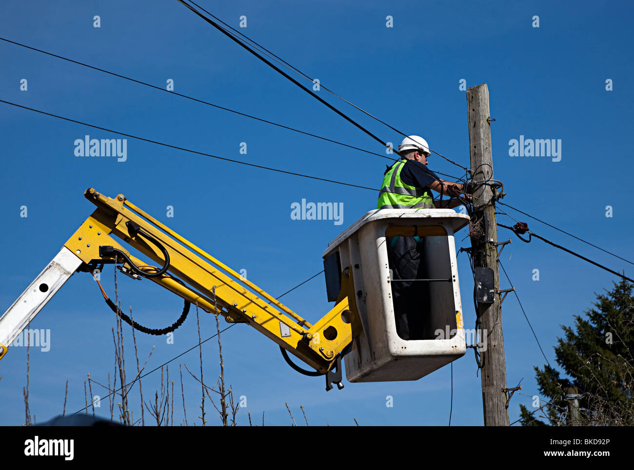 British Telecom ingénieur dans la réparation des lignes de téléphone de levage sur poteau télégraphique Wales UK Banque D'Images