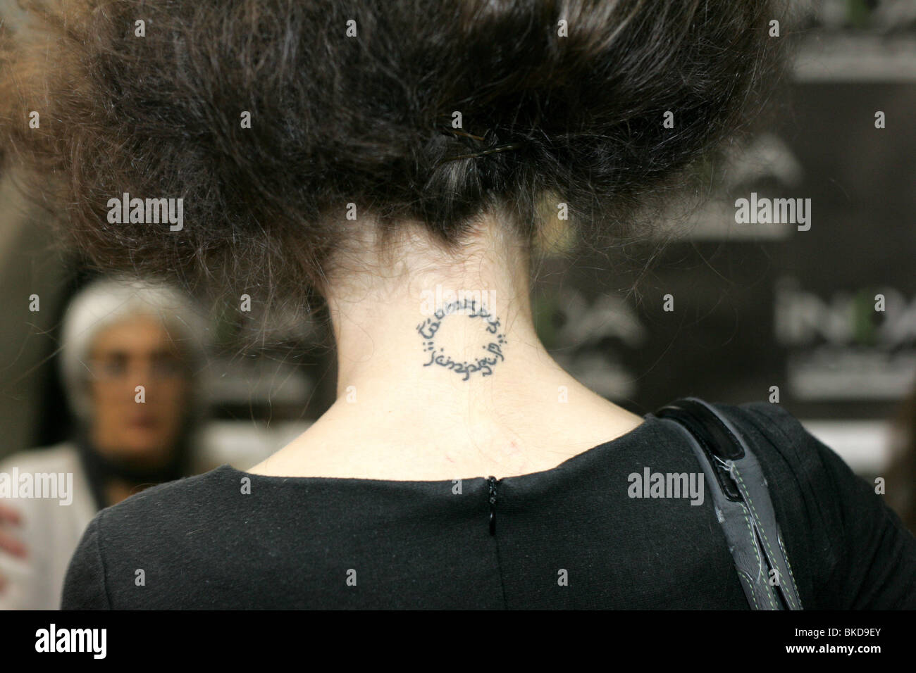 Modèle féminin avec un tatouage circulaire sur le cou. Banque D'Images