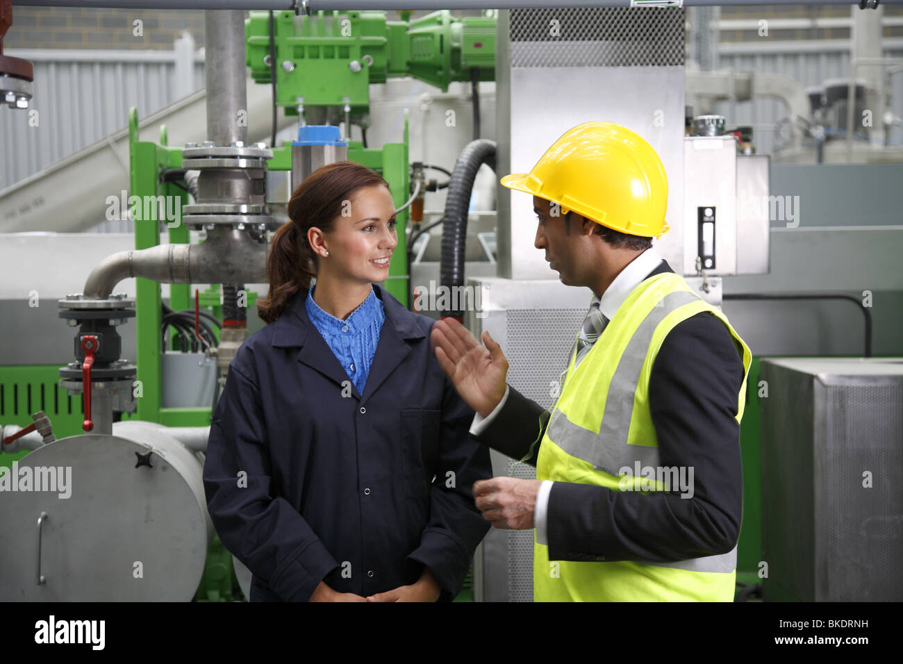 Femme travailleur industriel, à une réunion avec l'Asian male directeur d'usine. Banque D'Images