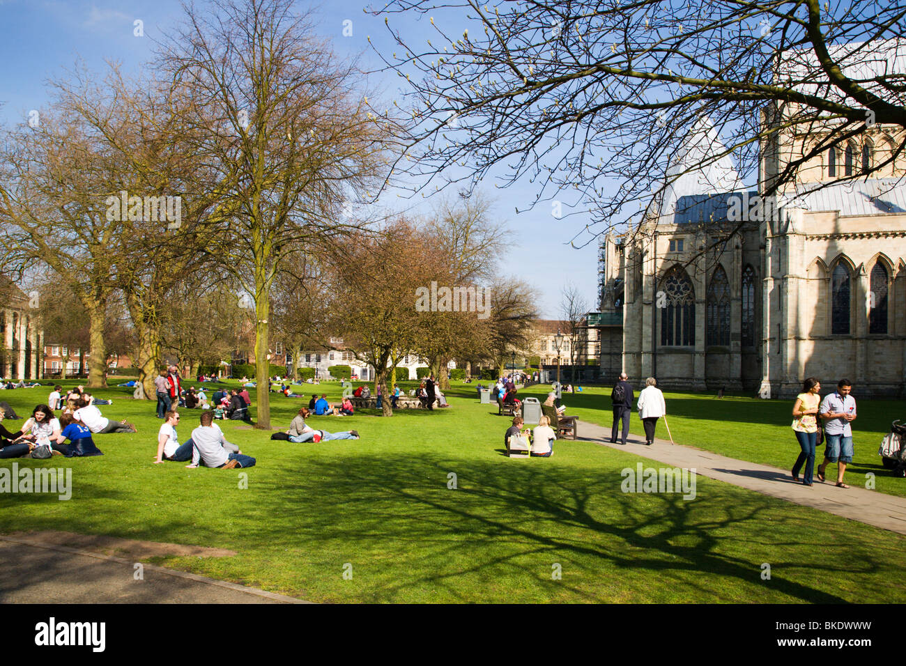 Des gens assis sur l'herbe dans la Deans Park York Yorkshire UK Banque D'Images