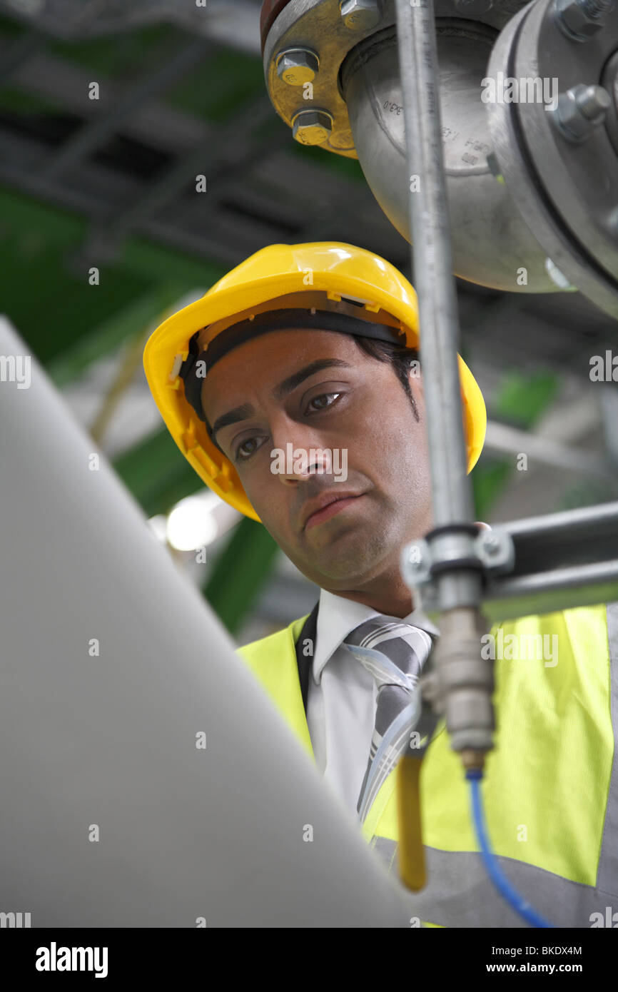 Gestionnaire d'usine asiatique portant des contrôles de l'équipement de sécurité machine Banque D'Images