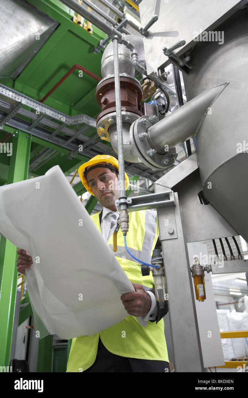 Gestionnaire d'usine asiatique portant des contrôles de l'équipement de sécurité machine Banque D'Images