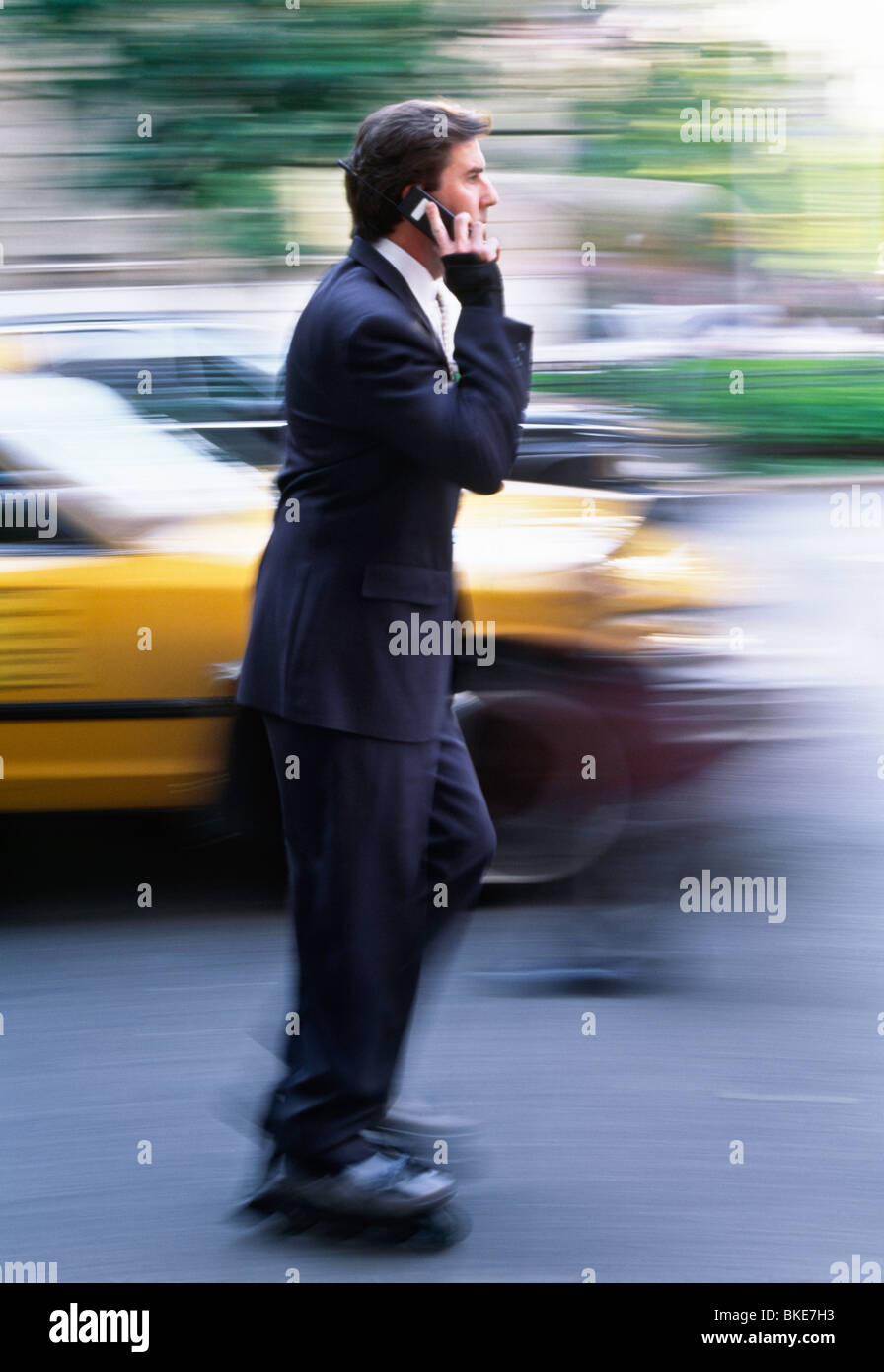 Homme d'affaires Skating on City Street, NYC, Etats-Unis 1990s Banque D'Images