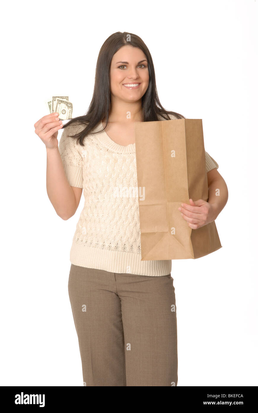 Femme heureuse tenant un fan d'argent liquide et un sac à provisions en papier, isolé sur blanc avec un espace de copie pour le succès financier et les concepts de vente au détail. Banque D'Images