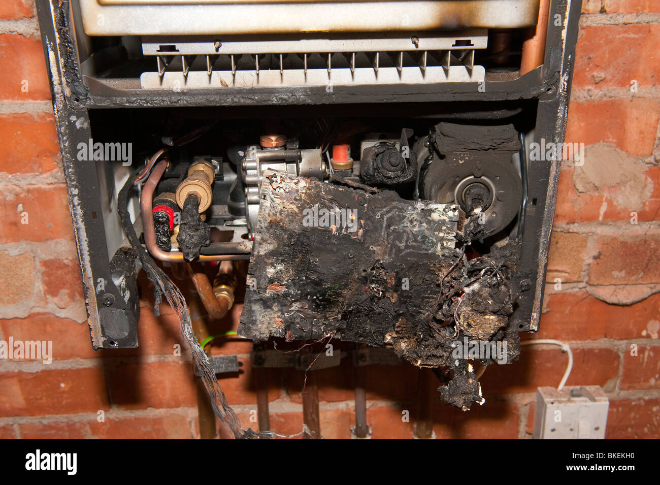 Chaudière domestique brûlé et panneau de contrôle suite à un incendie causé par une panne électrique à l'intérieur du circuit de commande Banque D'Images