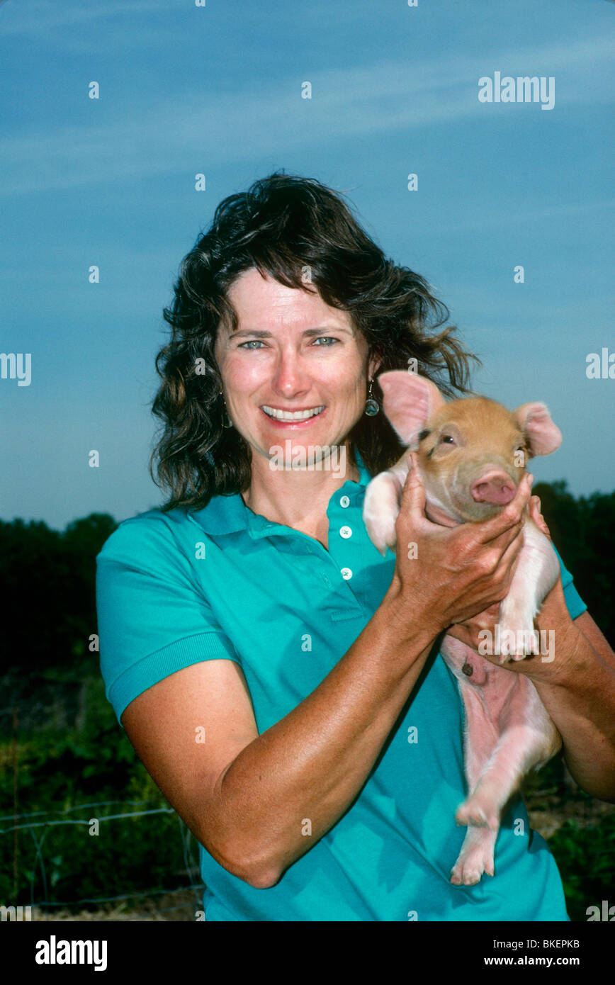 Woman holding newborn piglet commerciale Banque D'Images
